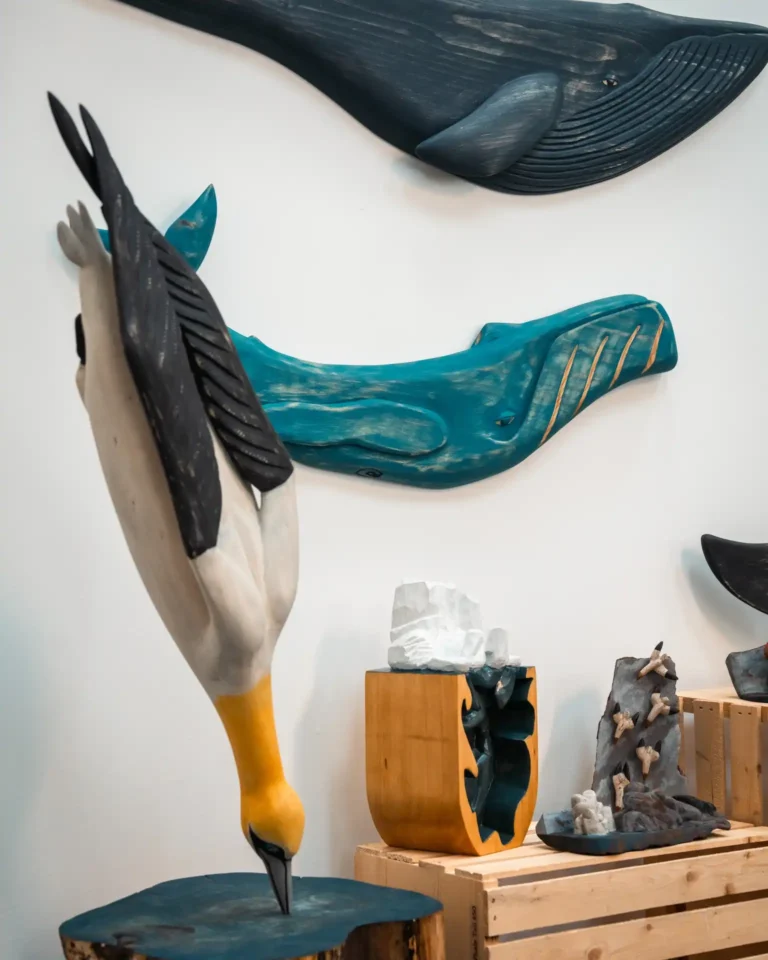 Handcrafted wood carvings by Come From Away Carvings, featuring a gannet bird and other art pieces.
